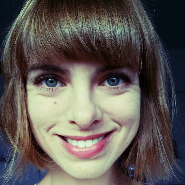 Anna Szylar – menadżerka kultury. Portret. W kadrze, ukazana twarz. Młoda, uśmiechnięta kobieta. Brązowe włosy, niebieskie oczy.